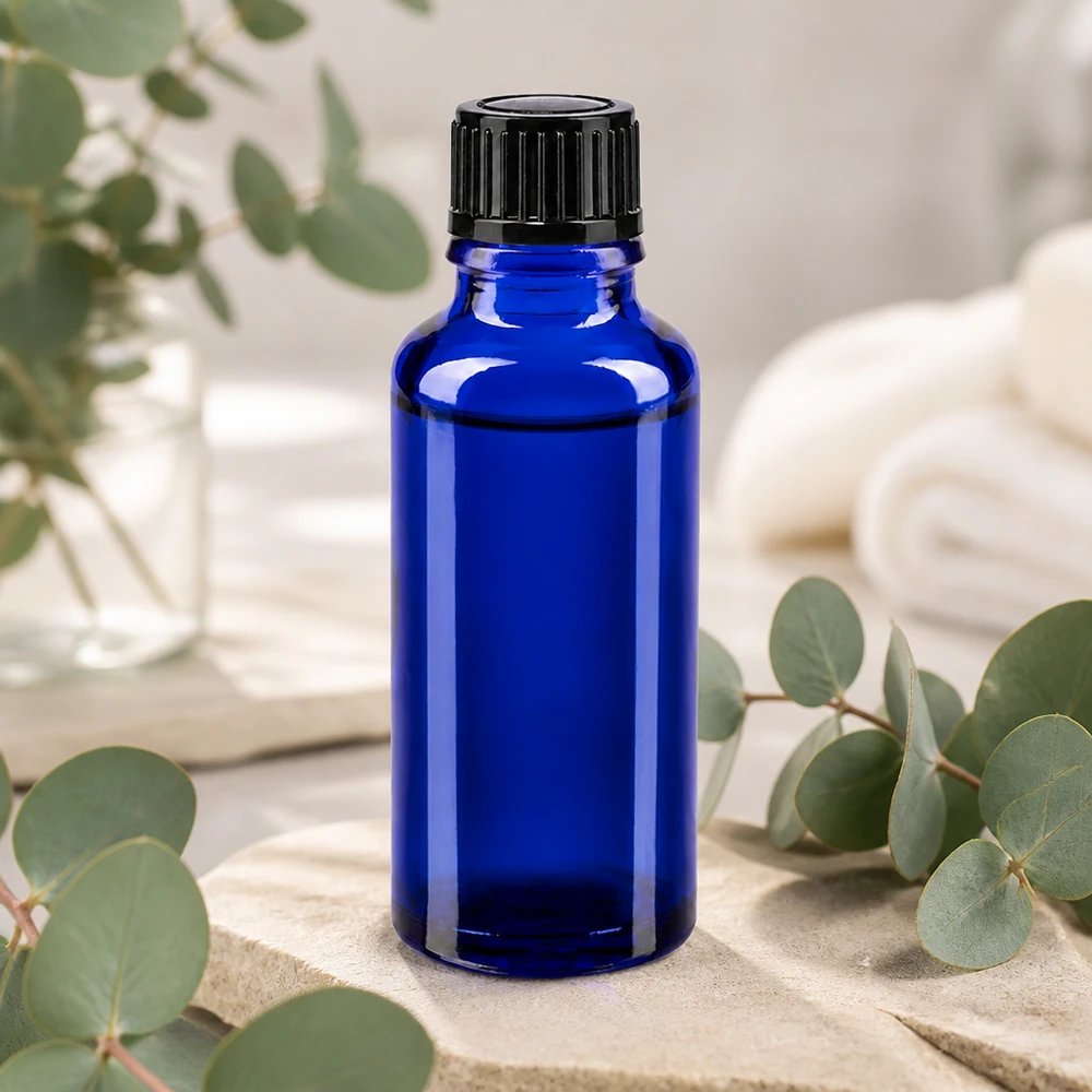 Botella de farmacia azul 30ml tapón cuentagotas 1mm negro estándar Frasco de cristal azul cobalto de 30 ml con tapón dosificador negro, sobre una piedra natural con ramitas de eucalipto