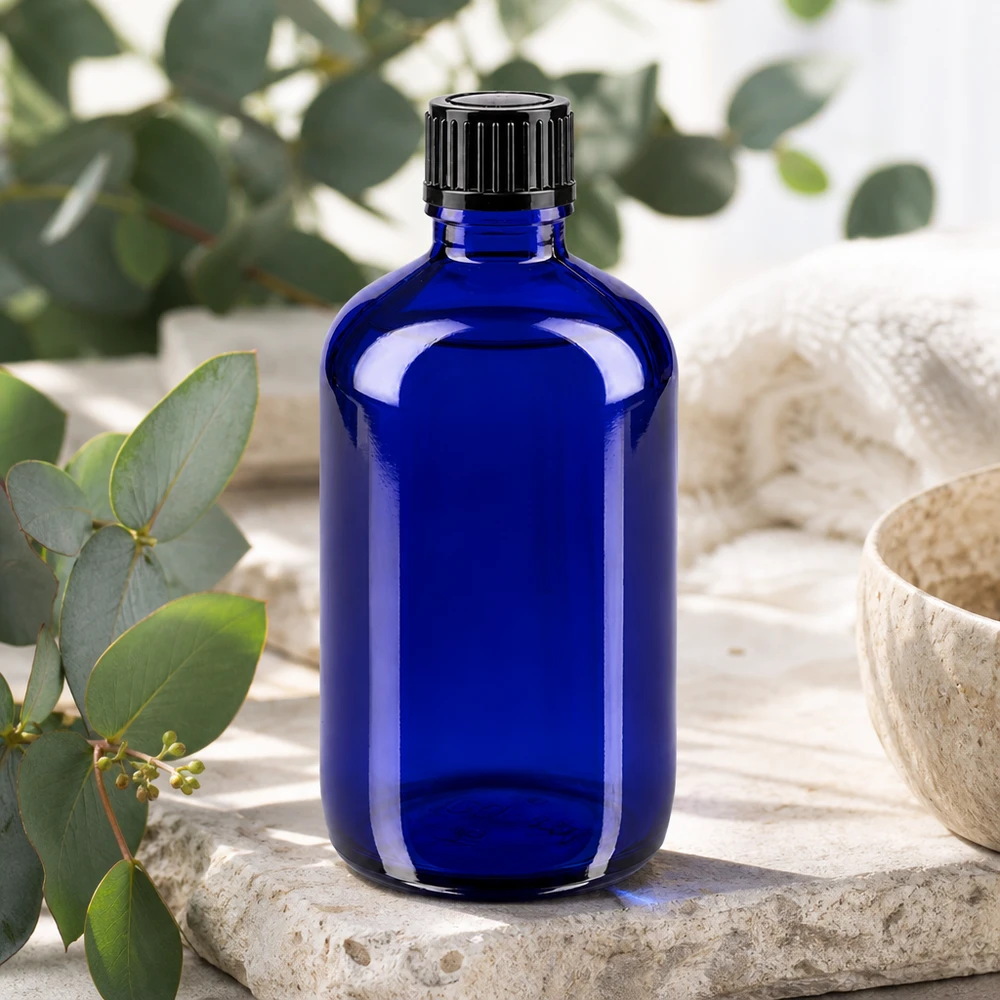 Frasco de farmacia azul de 100 ml con tapón estándar negro sobre piedra natural con aroma a eucalipto