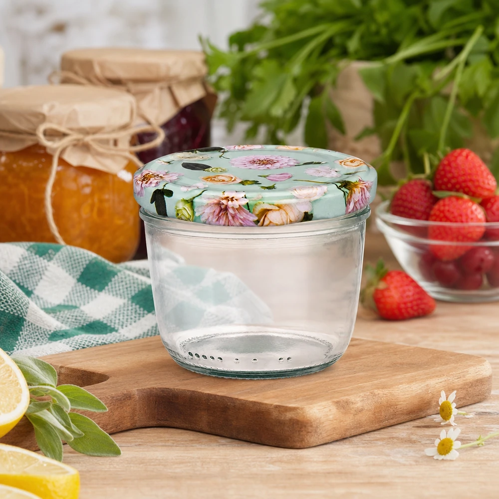 Vasos de 230 ml con tapa floral BasicSeal sobre tabla de madera, escena de cocina con mermelada, fresas y hierbas aromáticas