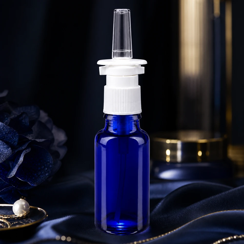 Frasco azul de 20 ml para spray nasal, de cristal de farmacia, con mecanismo de dosificación blanco sobre tela de seda