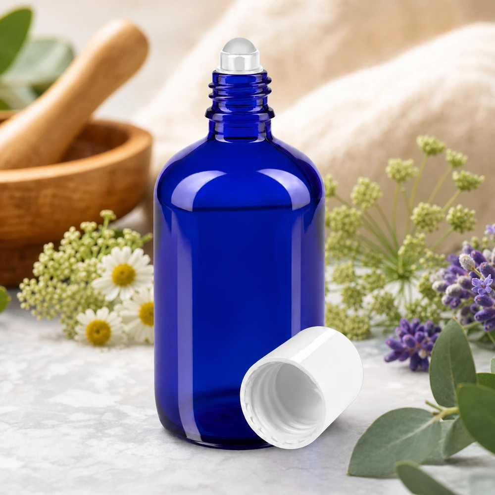 Frasco azul de ApoGlas con rodillo de 100 ml con hierbas y un mortero de madera al fondo