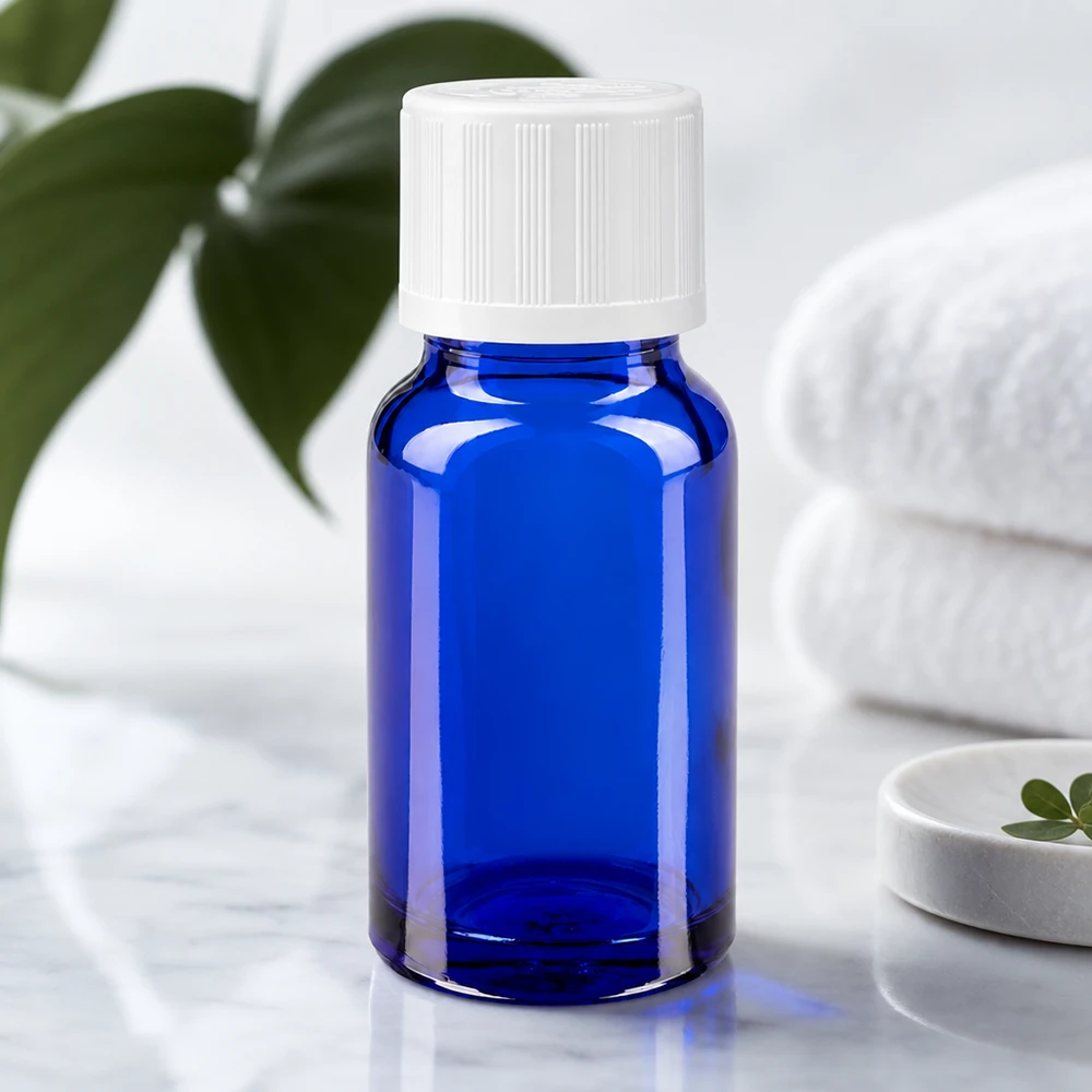 Botella de farmacia azul 10ml tapón cuentagotas blanco a prueba de niños estándar Frasco de farmacia azul de 10 ml con tapón de seguridad para niños de color blanco, sobre una superficie de mármol junto a unas toallas dobladas