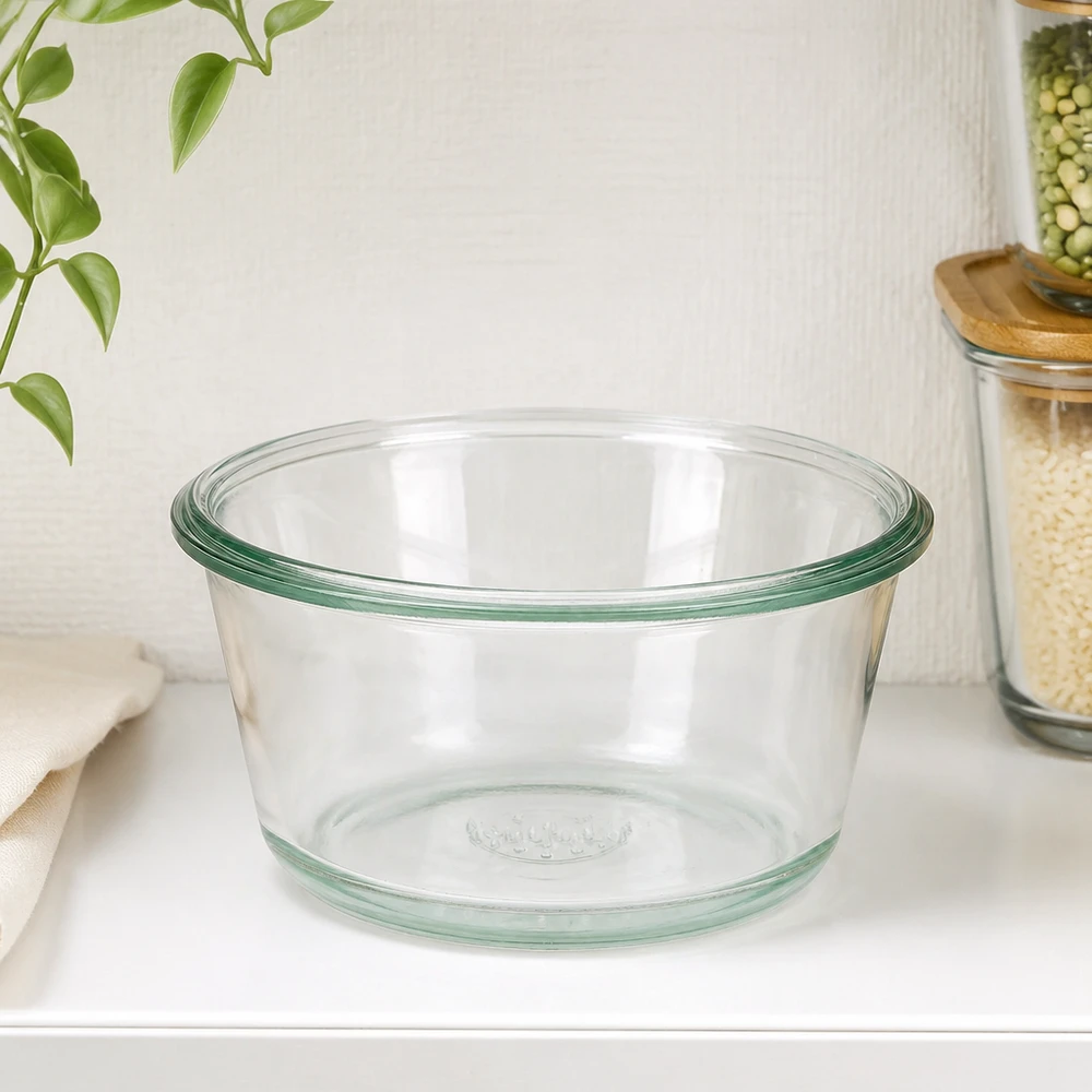 Tarro gourmet 290ml WECK RR100 WECK RR100 290ml tarro gourmet vacío sobre encimera de cocina blanca junto a tarros de almacenaje y planta verde